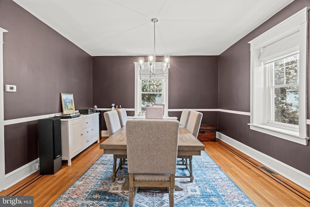 dining room featuring a chandelier, plenty of natural light, and light wood-style floors