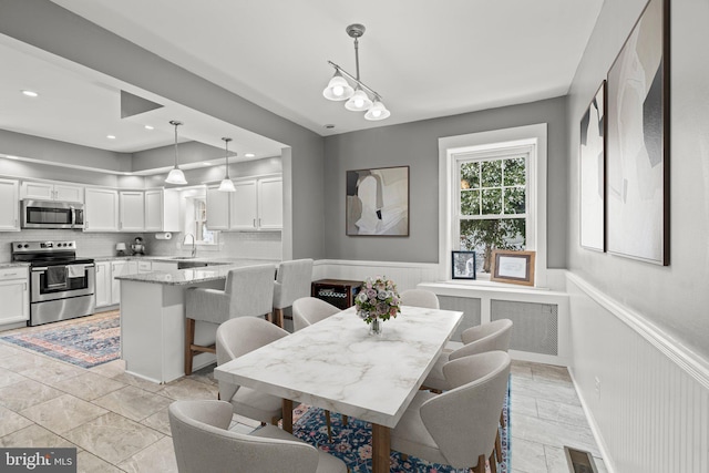 dining space featuring recessed lighting, radiator, a wainscoted wall, and visible vents