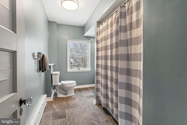 full bathroom featuring curtained shower, stone finish flooring, baseboards, and toilet