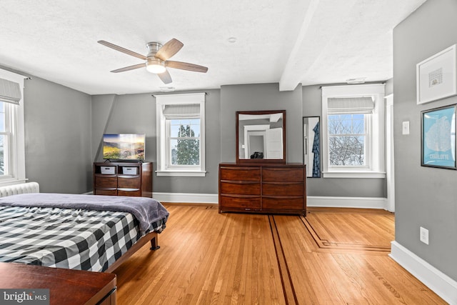 bedroom featuring multiple windows, wood finished floors, and baseboards