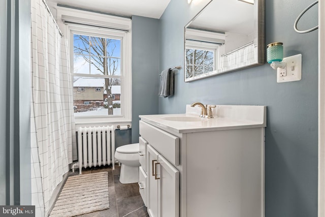 bathroom featuring radiator heating unit, plenty of natural light, vanity, and toilet