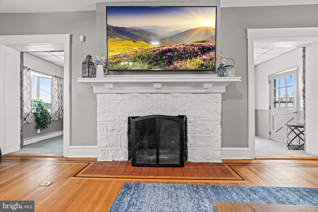 room details with a baseboard radiator, a paneled ceiling, and wood finished floors