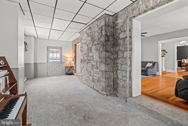 carpeted living area with a drop ceiling