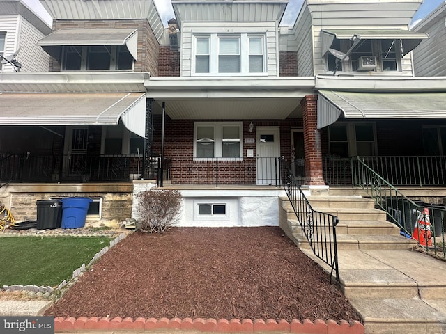 exterior space featuring covered porch and brick siding