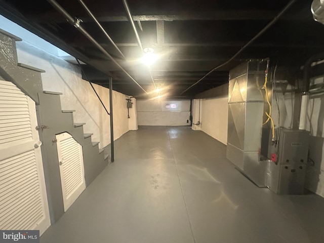 unfinished basement with heating unit and stairway