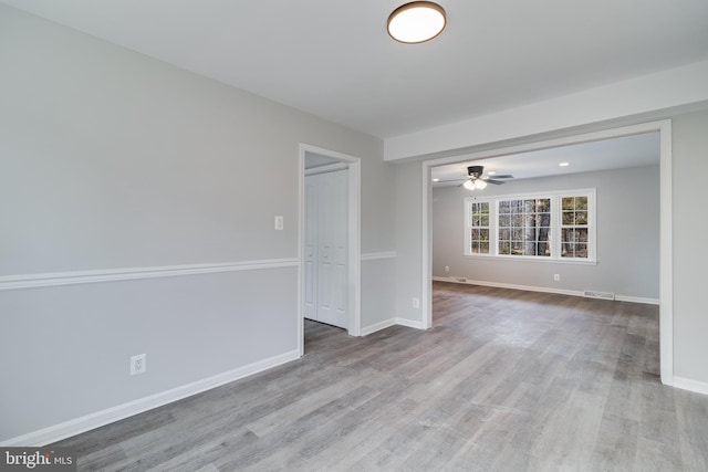 spare room featuring visible vents, baseboards, and wood finished floors