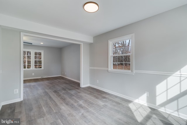 interior space with baseboards, wood finished floors, and a healthy amount of sunlight