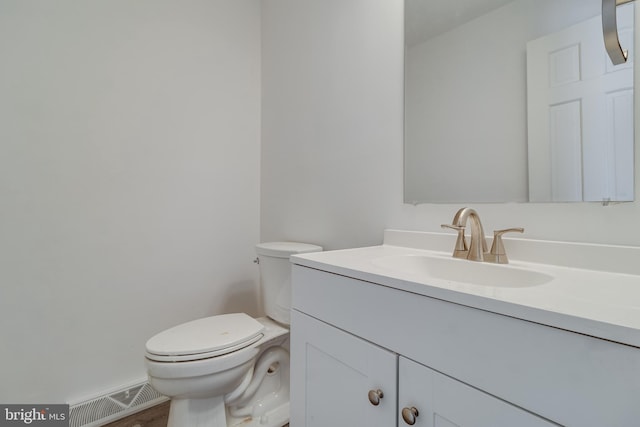 bathroom with visible vents, vanity, and toilet