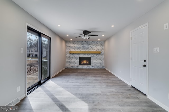 unfurnished living room featuring recessed lighting, a fireplace, wood finished floors, visible vents, and a ceiling fan