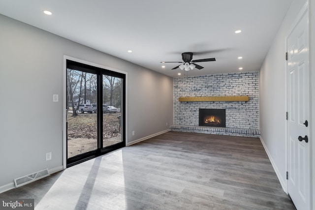 unfurnished living room with recessed lighting, a brick fireplace, visible vents, and baseboards