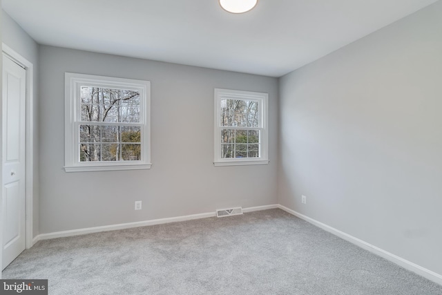 carpeted spare room with baseboards and visible vents