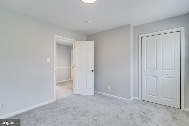 unfurnished bedroom with carpet floors, baseboards, and a closet