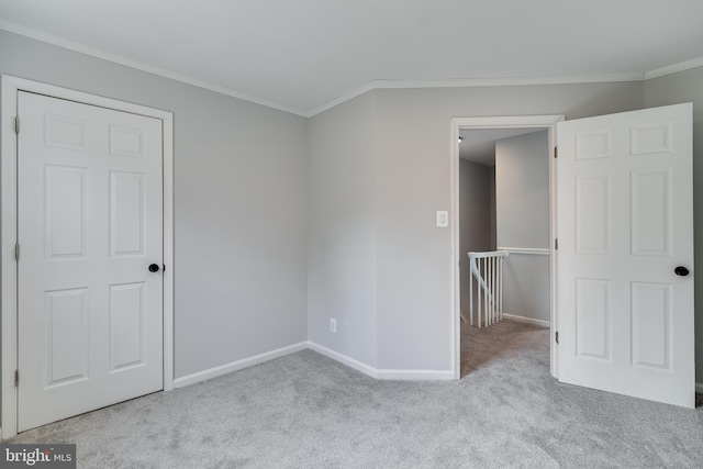 unfurnished bedroom with carpet, ornamental molding, and baseboards