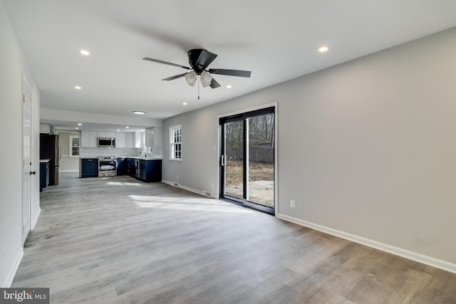 unfurnished living room featuring light wood-type flooring, baseboards, a ceiling fan, and recessed lighting