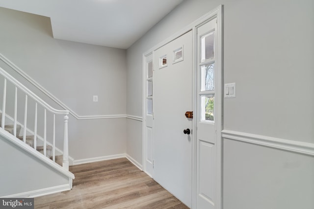 entrance foyer with stairway, baseboards, and wood finished floors