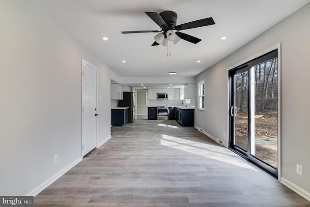 unfurnished living room with light wood-style floors, recessed lighting, and baseboards