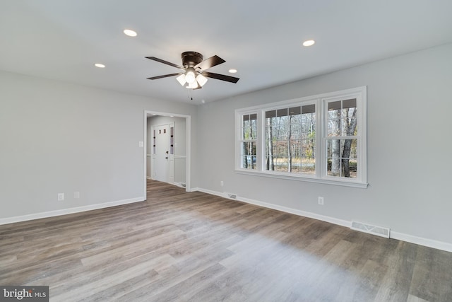 spare room with recessed lighting, visible vents, baseboards, and wood finished floors