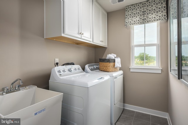 clothes washing area with dark tile patterned flooring, a sink, baseboards, cabinet space, and washer and clothes dryer