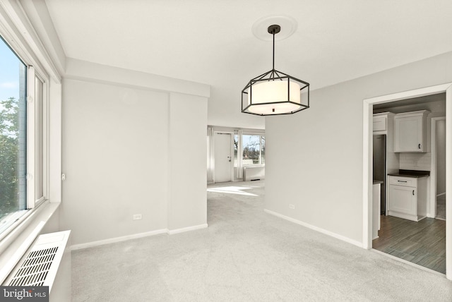 interior space featuring light colored carpet, visible vents, and baseboards