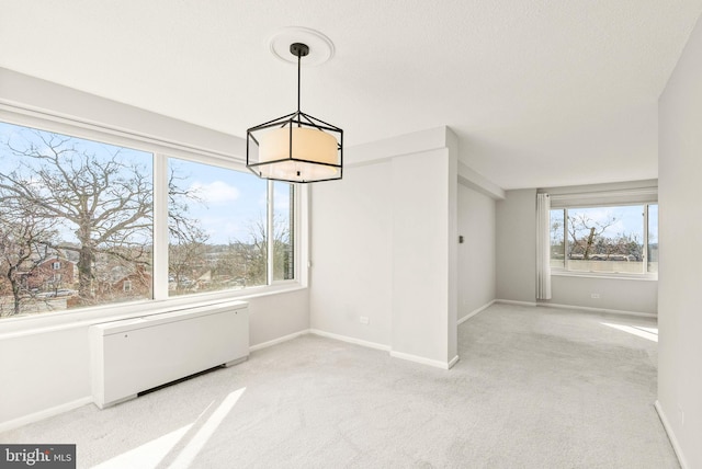 unfurnished dining area with radiator heating unit, carpet flooring, and baseboards