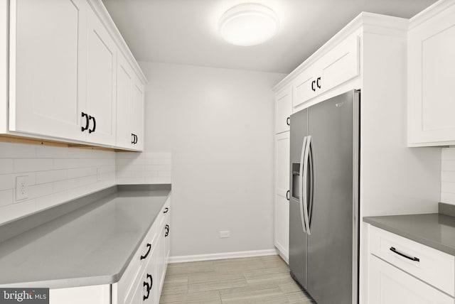 kitchen featuring tasteful backsplash, white cabinetry, and stainless steel refrigerator with ice dispenser