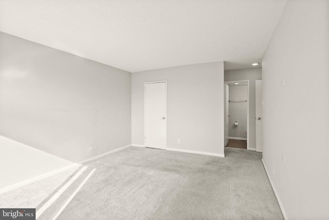 unfurnished bedroom featuring carpet flooring, baseboards, and ensuite bathroom