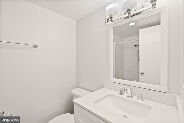 bathroom with toilet, a shower with door, and vanity