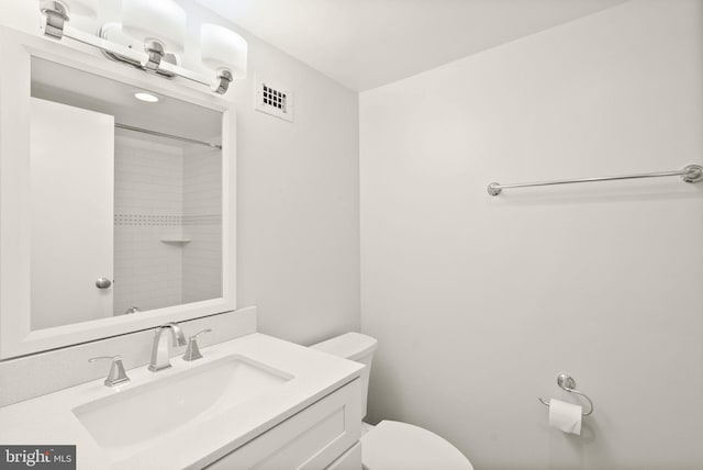 full bath with visible vents, a shower, vanity, and toilet