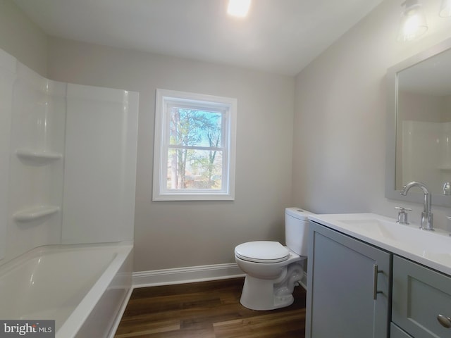 full bath featuring toilet, vanity, baseboards, and wood finished floors