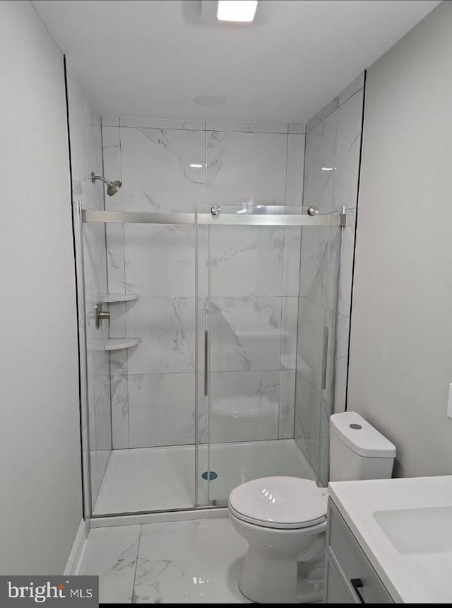 full bath featuring marble finish floor, a stall shower, vanity, and toilet