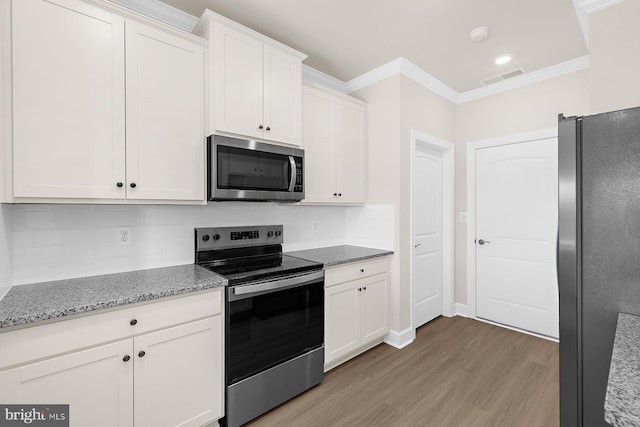 kitchen with crown molding, stainless steel appliances, backsplash, light wood-style flooring, and white cabinetry