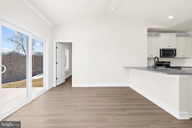 kitchen featuring lofted ceiling, white cabinetry, baseboards, light wood-type flooring, and stainless steel electric range oven