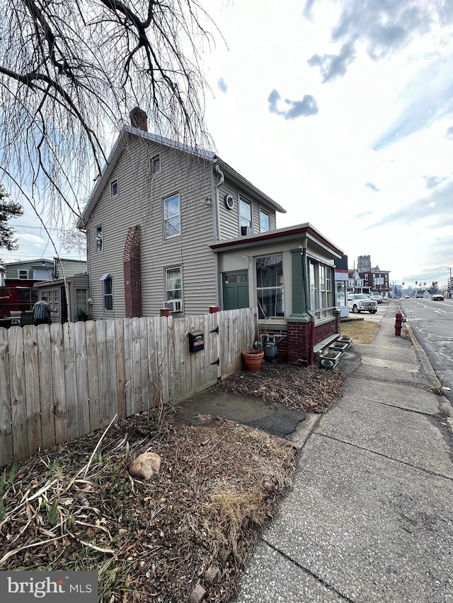 view of side of property with a fenced front yard and a chimney