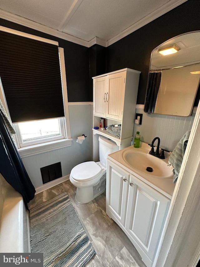 bathroom featuring toilet, ornamental molding, and vanity