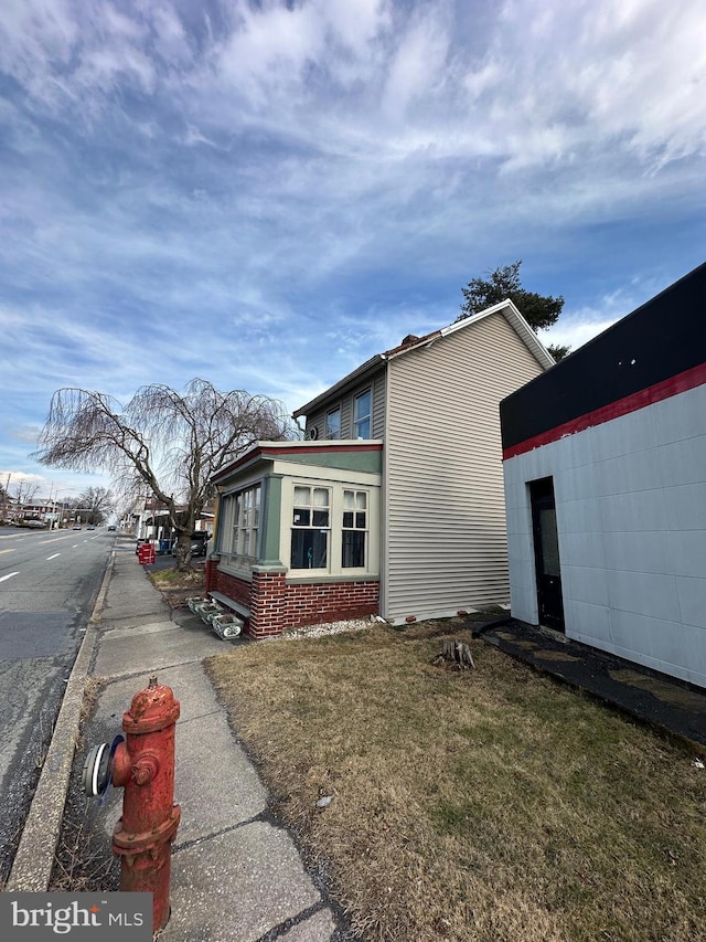 view of side of home with a lawn and brick siding