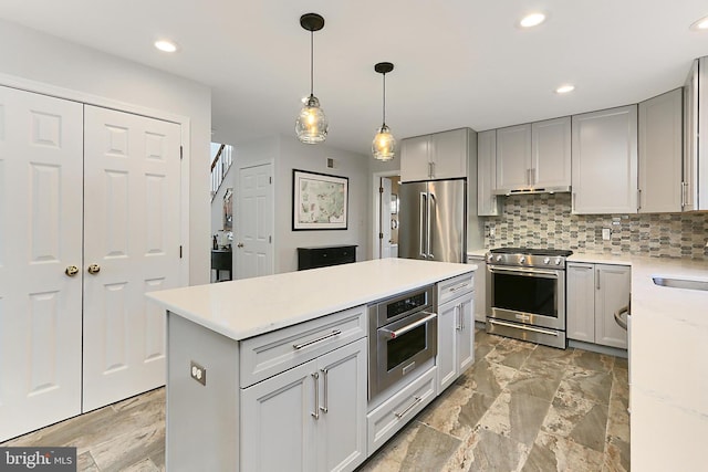 kitchen featuring recessed lighting, high end appliances, decorative backsplash, and gray cabinetry