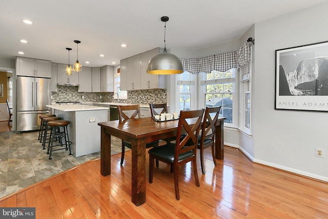 dining area with recessed lighting, light wood-style flooring, and baseboards