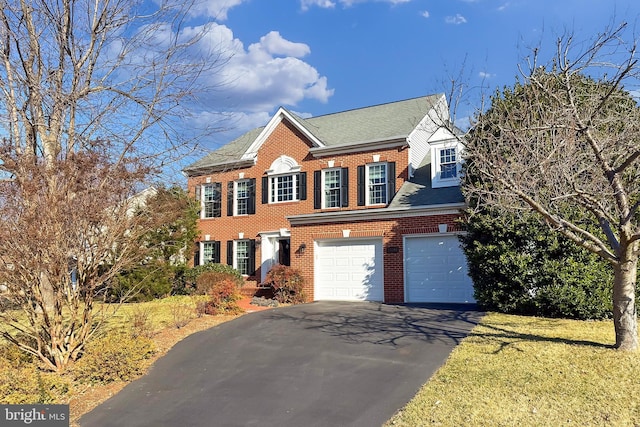 view of front of house with roof with shingles, aphalt driveway, and brick siding