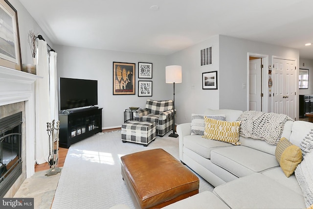 living area featuring a premium fireplace and visible vents