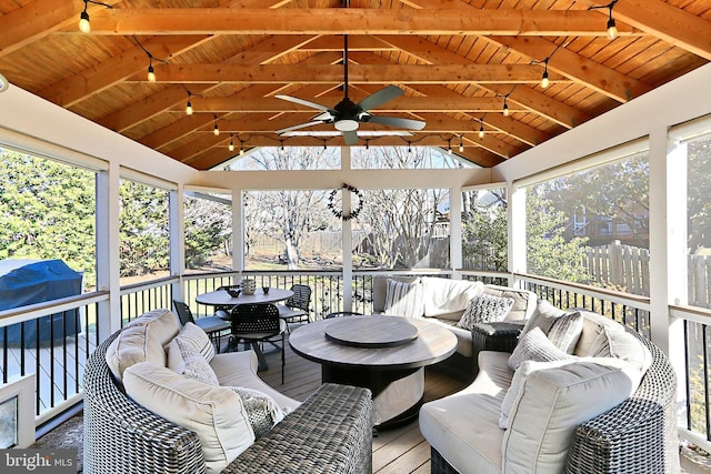 sunroom featuring a ceiling fan, wooden ceiling, and lofted ceiling with beams