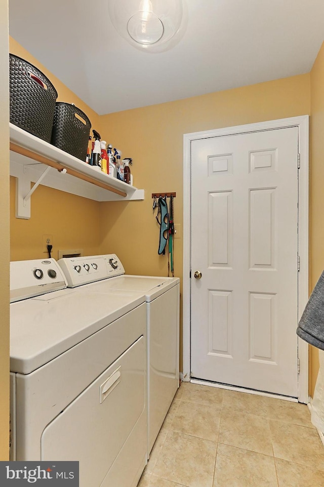 laundry area with washer and dryer, laundry area, and light tile patterned floors