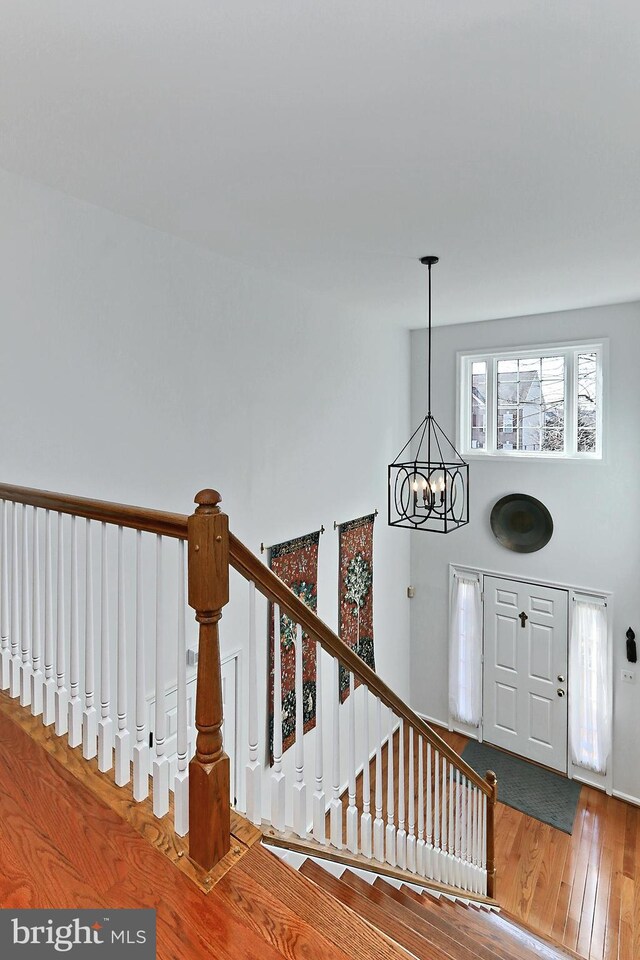 foyer featuring a chandelier, hardwood / wood-style floors, stairs, and a towering ceiling