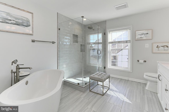 bathroom featuring visible vents, vanity, a freestanding bath, baseboards, and a shower stall