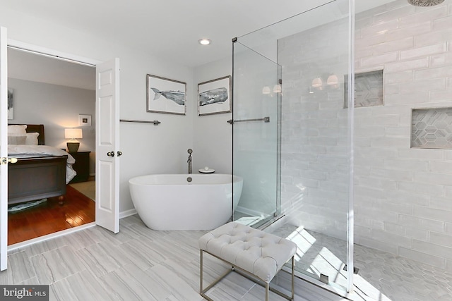 ensuite bathroom with ensuite bath, a soaking tub, and a tile shower