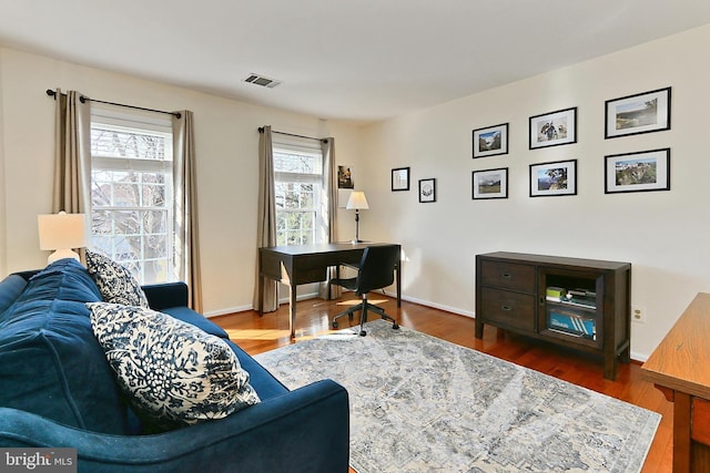 office featuring baseboards, visible vents, and wood finished floors