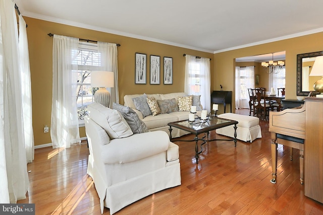 living area featuring a healthy amount of sunlight, light wood-style floors, and ornamental molding