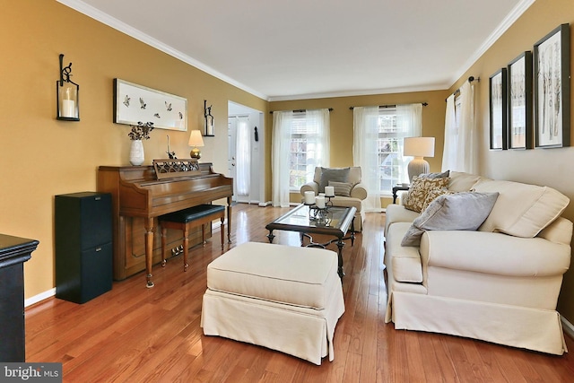 living room featuring crown molding, baseboards, and wood finished floors