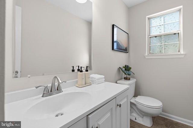 bathroom featuring toilet, baseboards, vanity, and tile patterned floors