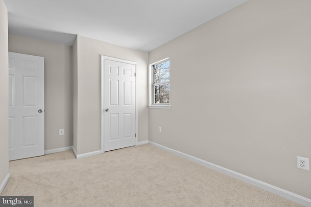 unfurnished bedroom featuring carpet floors and baseboards