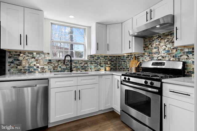 kitchen with appliances with stainless steel finishes, a sink, white cabinets, and under cabinet range hood